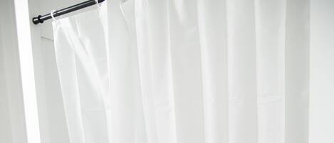 A white bathtub with a shower curtain in a bathroom.