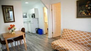 A compact living space with a dining area, kitchenette, and a bed. - Westview Centre Motel Ltd. (Powell River)