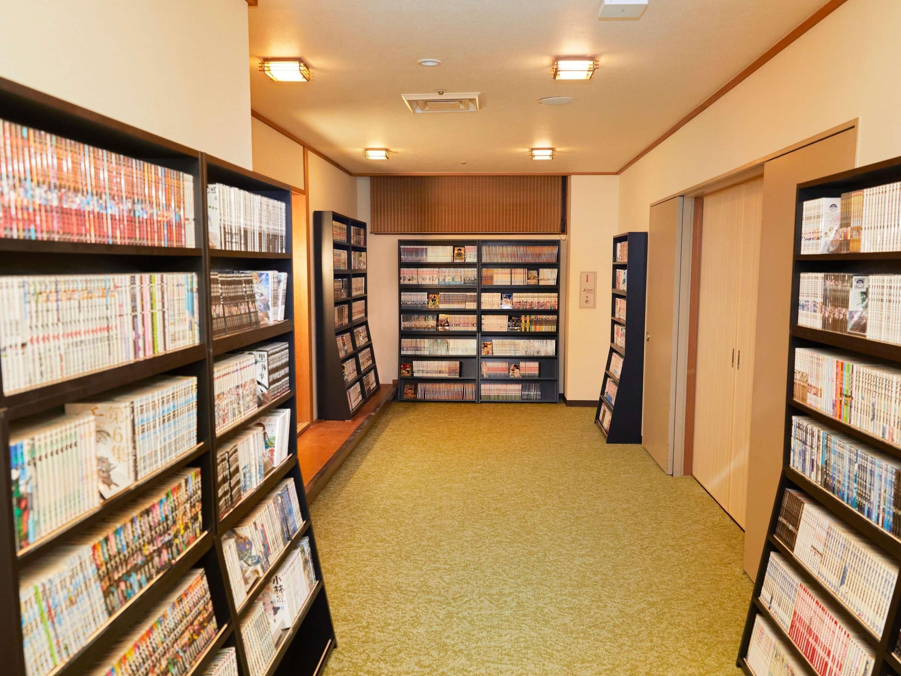 A library with bookshelves on both sides and a carpeted floor.