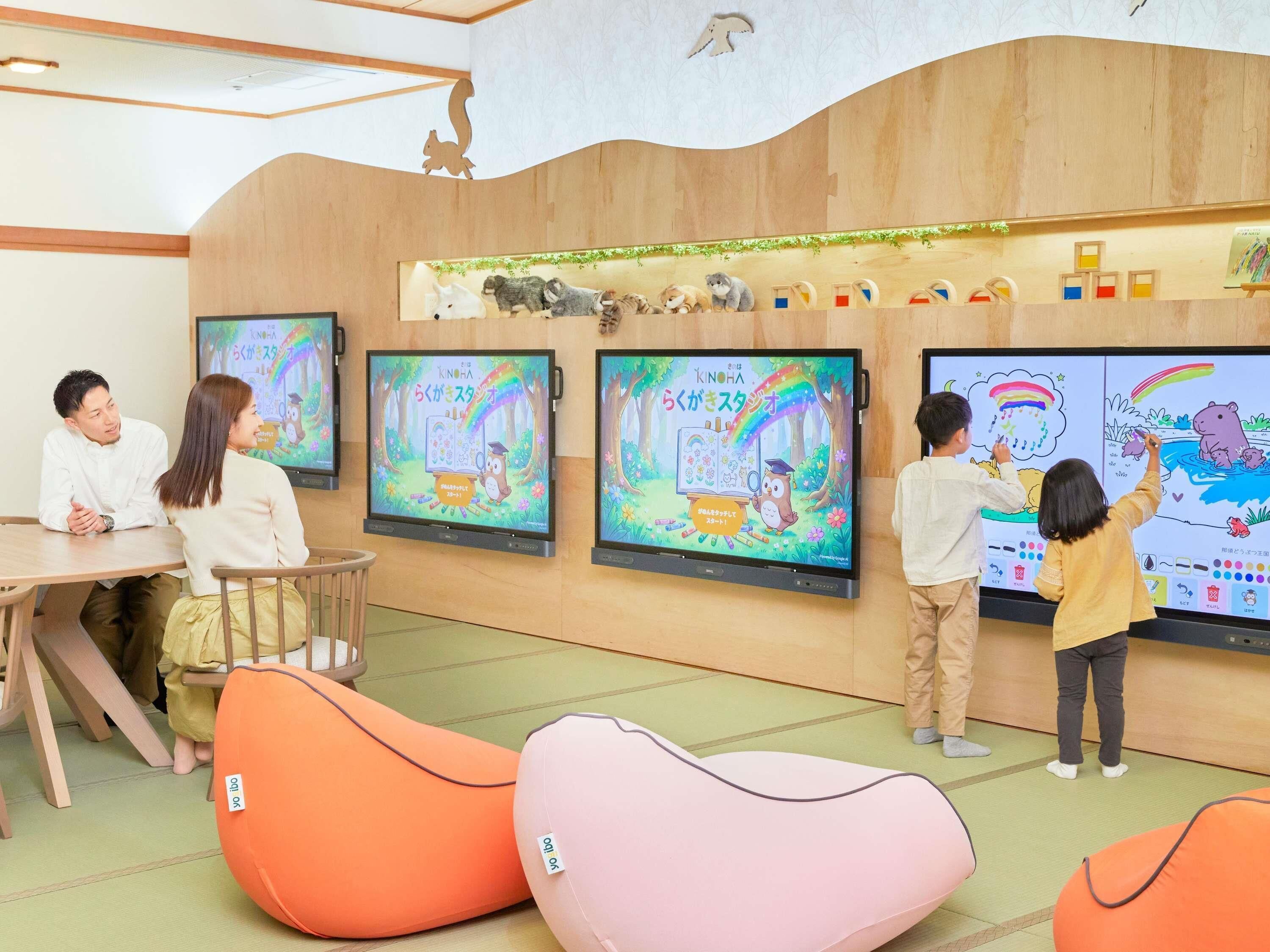 A children's learning area with interactive screens, seating, and educational toys.