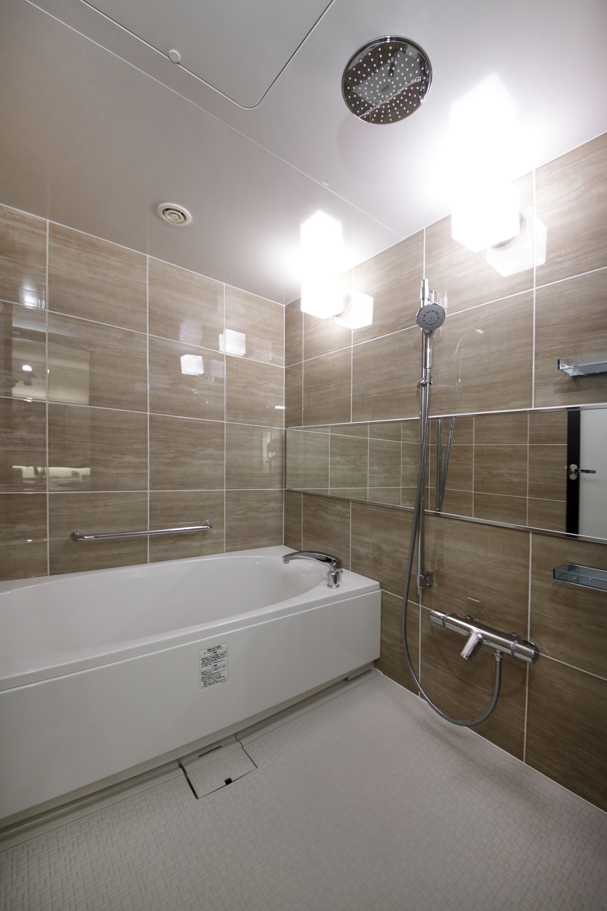 Un baño moderno con una bañera independiente, un cabezal de ducha manual y un perchero de pared.