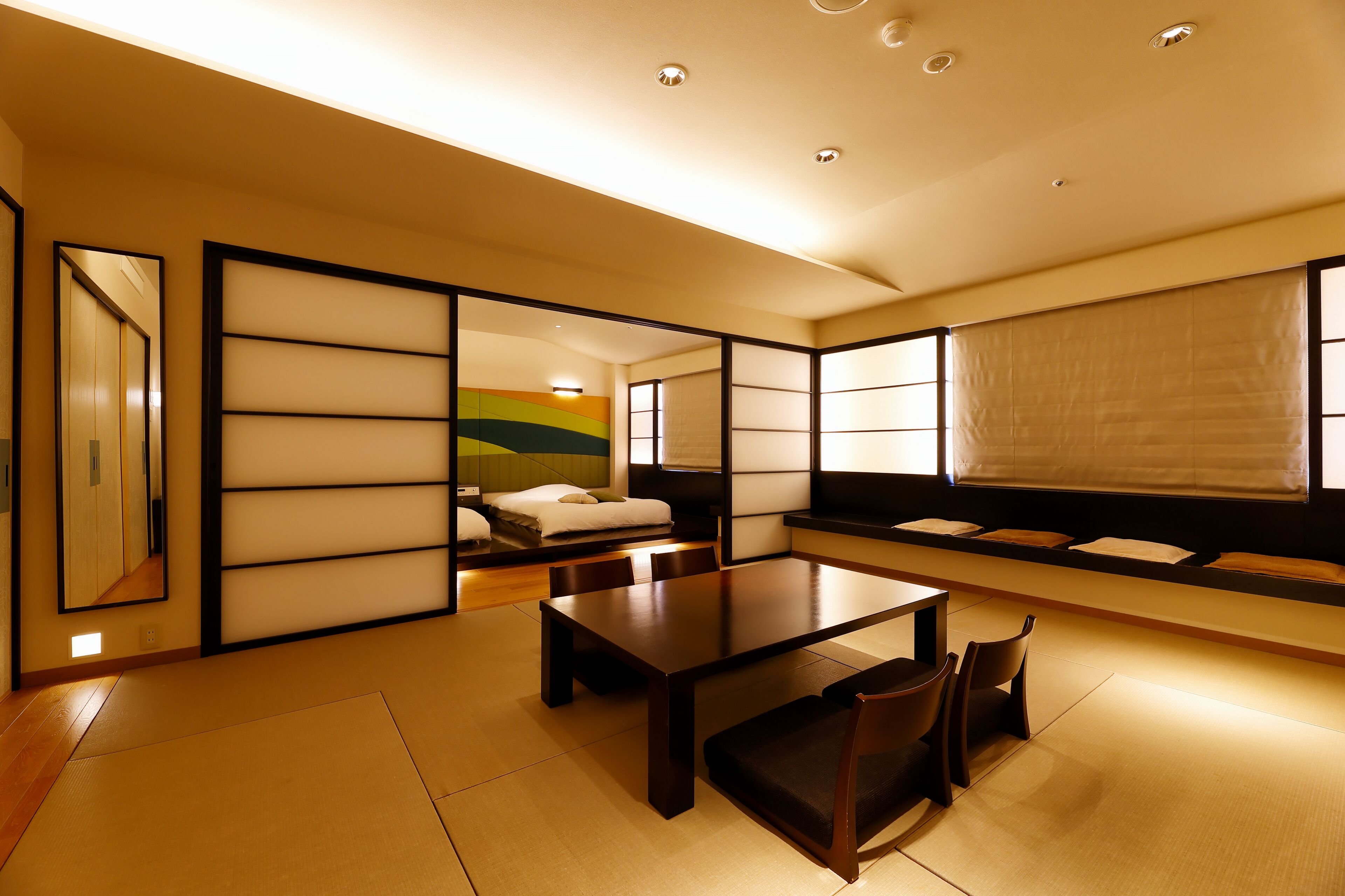 A traditional Japanese-style room with tatami flooring, a low table, and a futon bed.