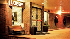 A lobby area with a bench, potted plants, and a sign reading "Lobby". - Cloud 9 Inn (Whitecourt)