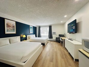 A modern hotel room with two beds, a desk, a chair, a TV, and a window with curtains.