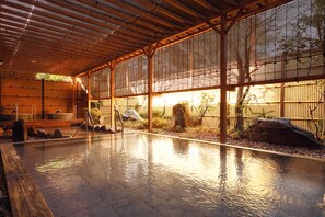 A traditional Japanese onsen with a wooden deck, a stone bath, and a bamboo fence. - Mercure Tottori Daisen Resort & Spa (Hoki)