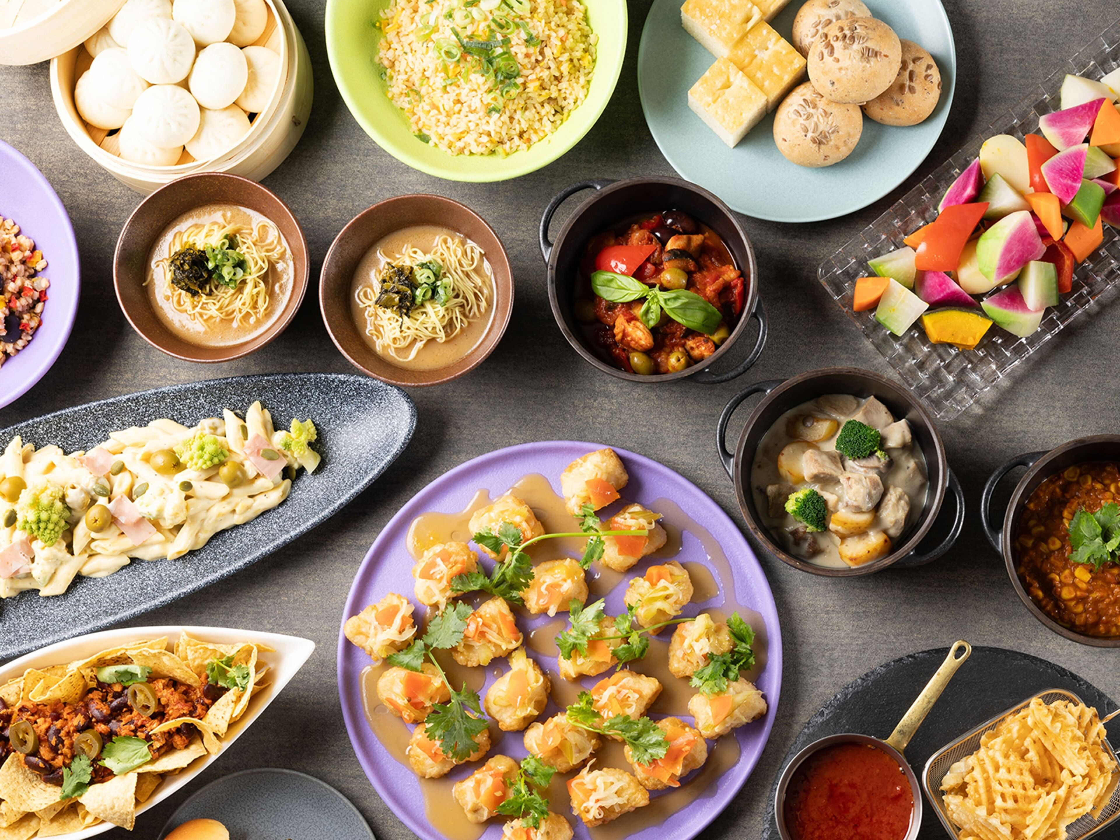 A variety of dishes including dumplings, noodles, and a plate of tacos.
