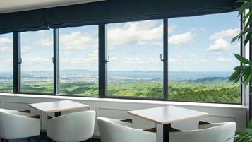 A room with a large window, a table, and four chairs.