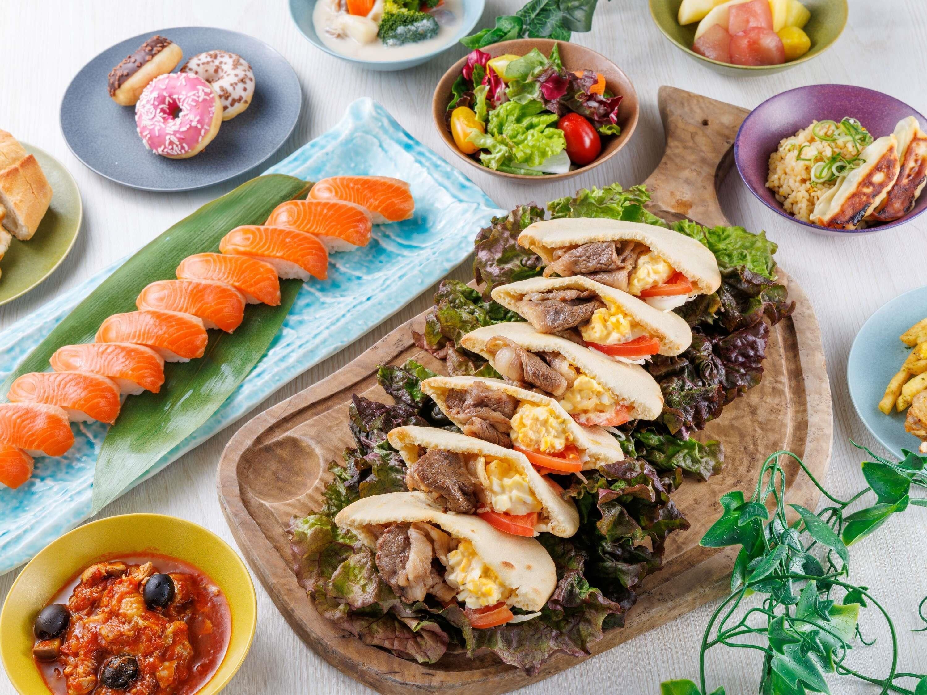 A variety of dishes including sushi, a salad, and a meat dish, suggesting a diverse meal selection.
