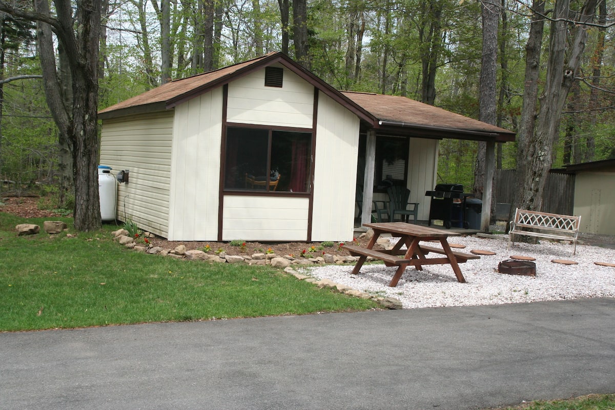 A small, single-story building with a sloped roof, a window, and a door.