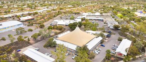 An aerial view of a commercial area with multiple buildings, parking lots, and roads.