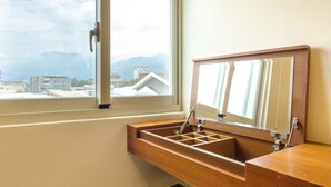 Une salle de bain avec une fenêtre, un meuble-lavabo en bois et un miroir.