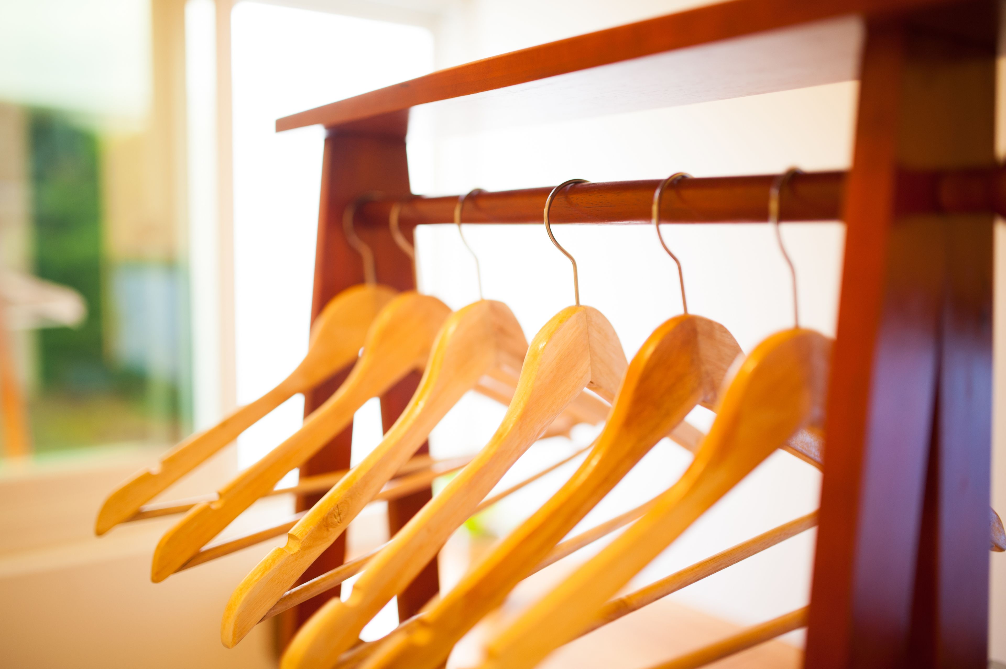 Un soporte de madera para cucharas con varias cucharas colgadas en ganchos.