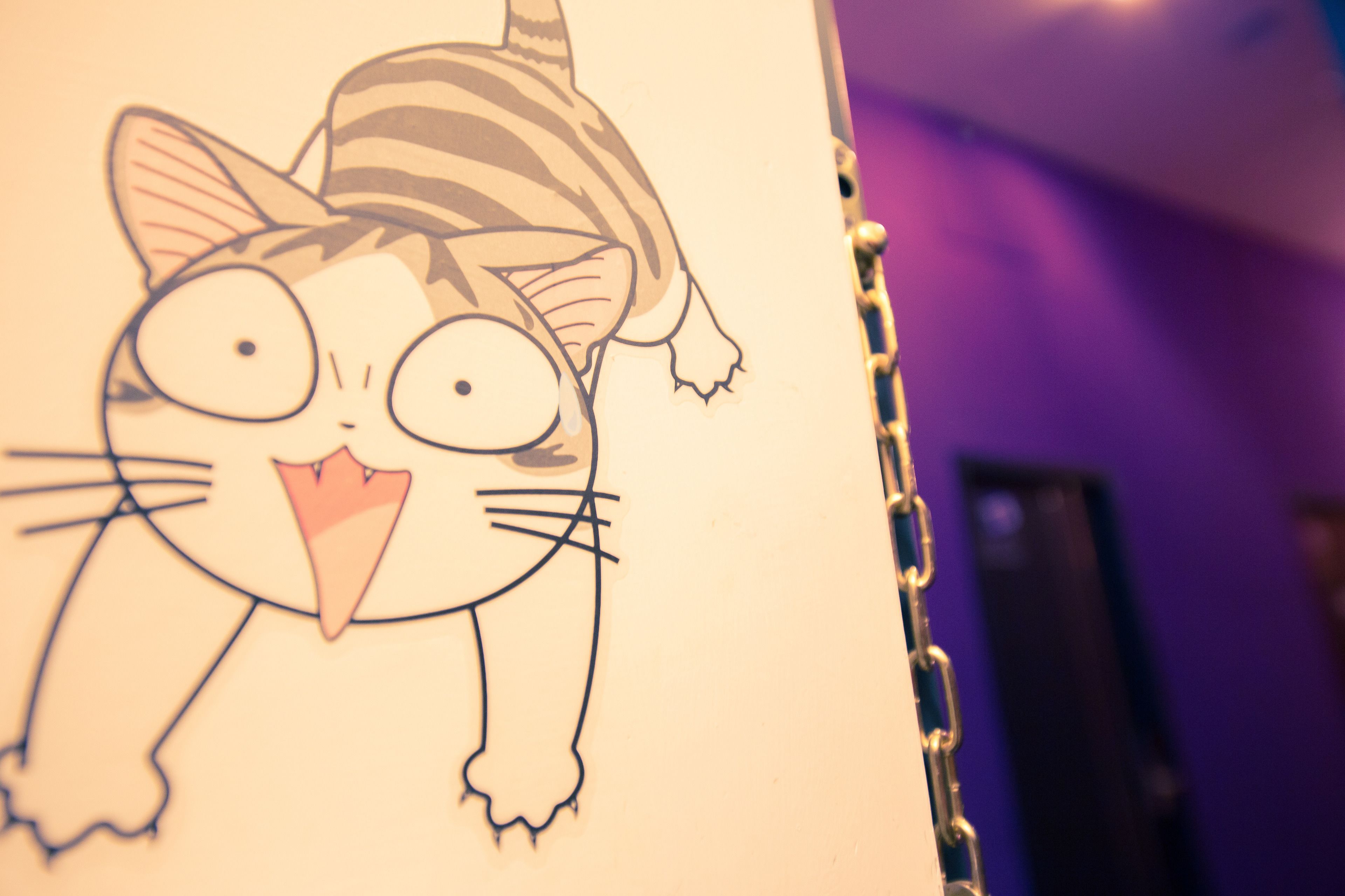 Ilustração de um gato de desenho animado na parede.