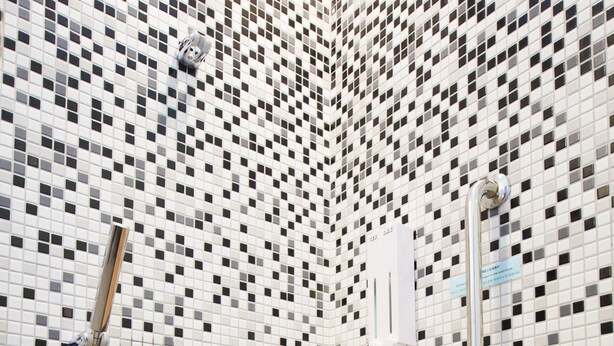 A bathroom with a tiled mosaic wall, a shower, and a wooden bench. - SleepBox Hotel - Ximen (Taipei)