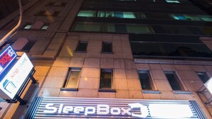 Una tienda SleepBox con fachada moderna, grandes ventanales de vidrio y una entrada visible.