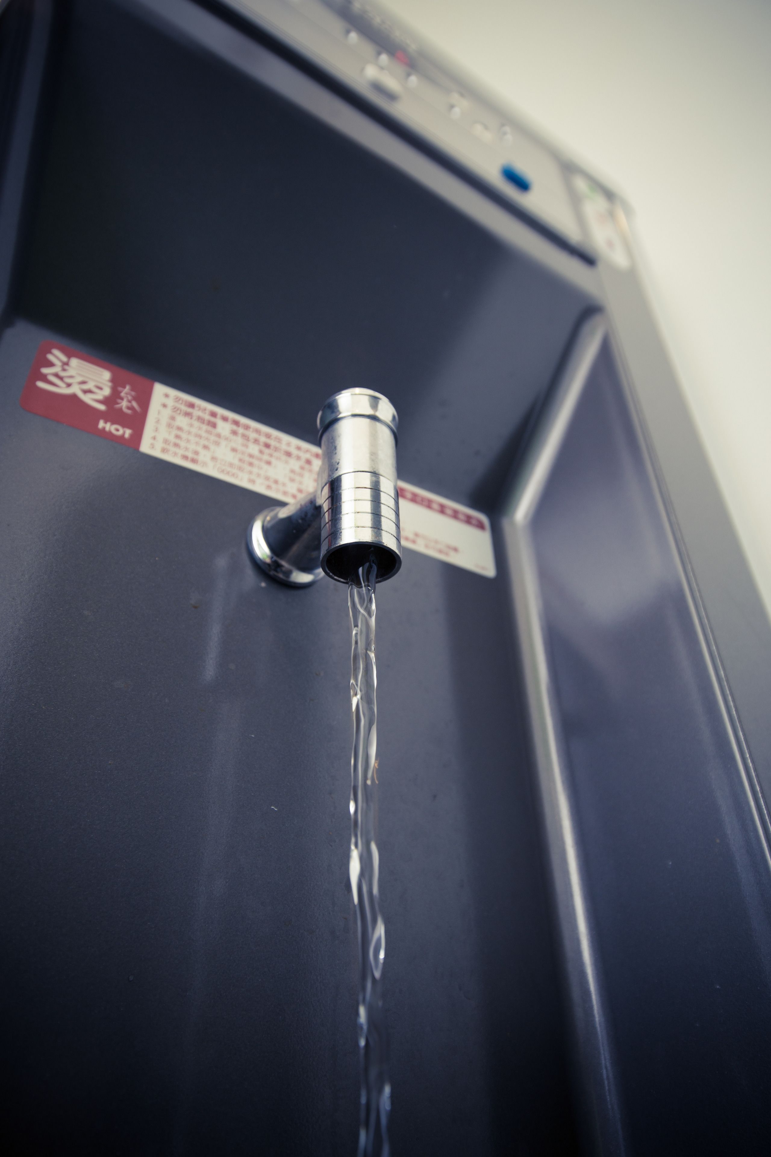 A water dispenser with a label and a tap.