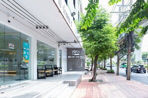 Fachada de una tienda con un letrero que dice "BED BY THA-PRA" y puerta de vidrio de entrada.
