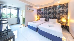 A hotel room with two beds, a piano, and a large window. - Bed by Tha-Pra Hotel and Apartment (Bangkok)