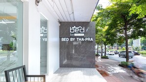 A modern building with a prominent sign reading "BED BY THA-PRA". - Bed by Tha-Pra Hotel and Apartment (Bangkok)