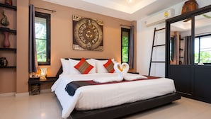 A spacious bedroom with a large bed, a decorative wall piece, and a view of greenery outside. - Koh Tao Heights Boutique Villas (Koh Tao)