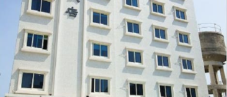Un hotel de varios pisos con fachada moderna, amplias ventanas y una entrada visible con puerta de cristal.