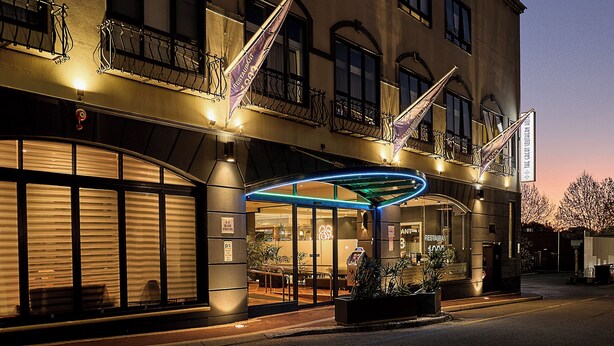A hotel with a modern facade, large windows, and a covered entrance area with plants. - Great Southern Hotel Perth (Perth)