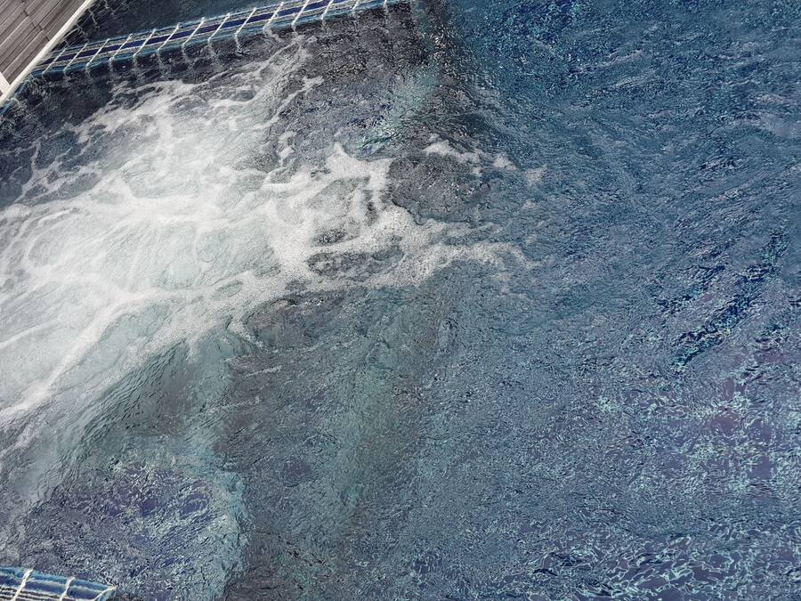 A pool with a tiled edge and a visible water feature.