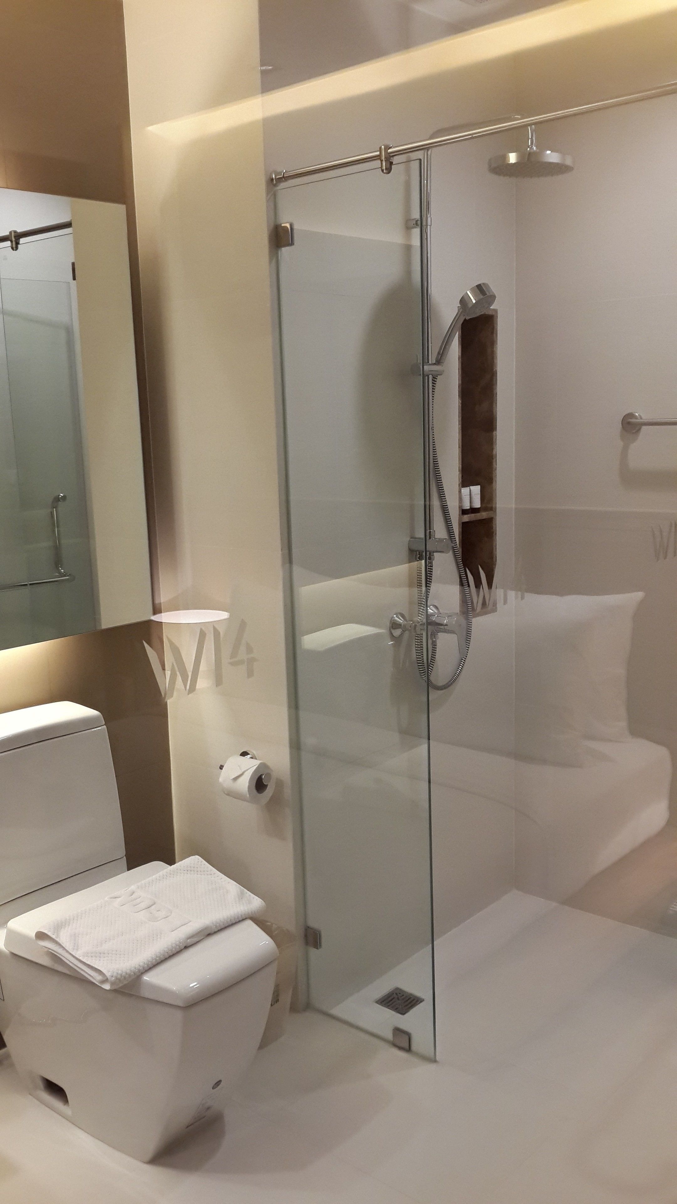 A modern bathroom with a glass-enclosed shower, a toilet, and a sink.
