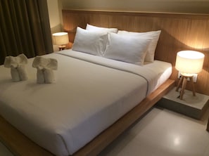 A neatly made bed with white linens, two bedside lamps, and two towels folded on the bed. - W14 Pattaya (Pattaya)