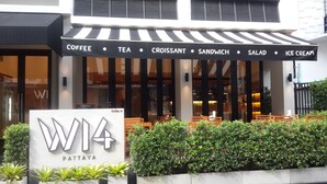 A restaurant with a signboard listing coffee, tea, croissant, sandwich, salad, and ice cream. - W14 Pattaya (Pattaya)
