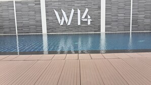 A swimming pool with a wooden deck in front, and a wall with the letters "W1" in white. - W14 Pattaya (Pattaya)