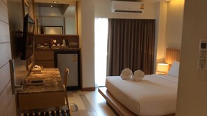A hotel room with a bed, a desk, a chair, a small kitchenette, and a TV. - W14 Pattaya (Pattaya)