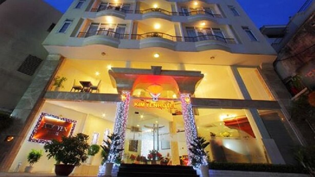 A multi-story hotel with a prominent entrance, balconies on each floor, and a well-lit facade. - Kim Yen Hotel (Ho Chi Minh City)