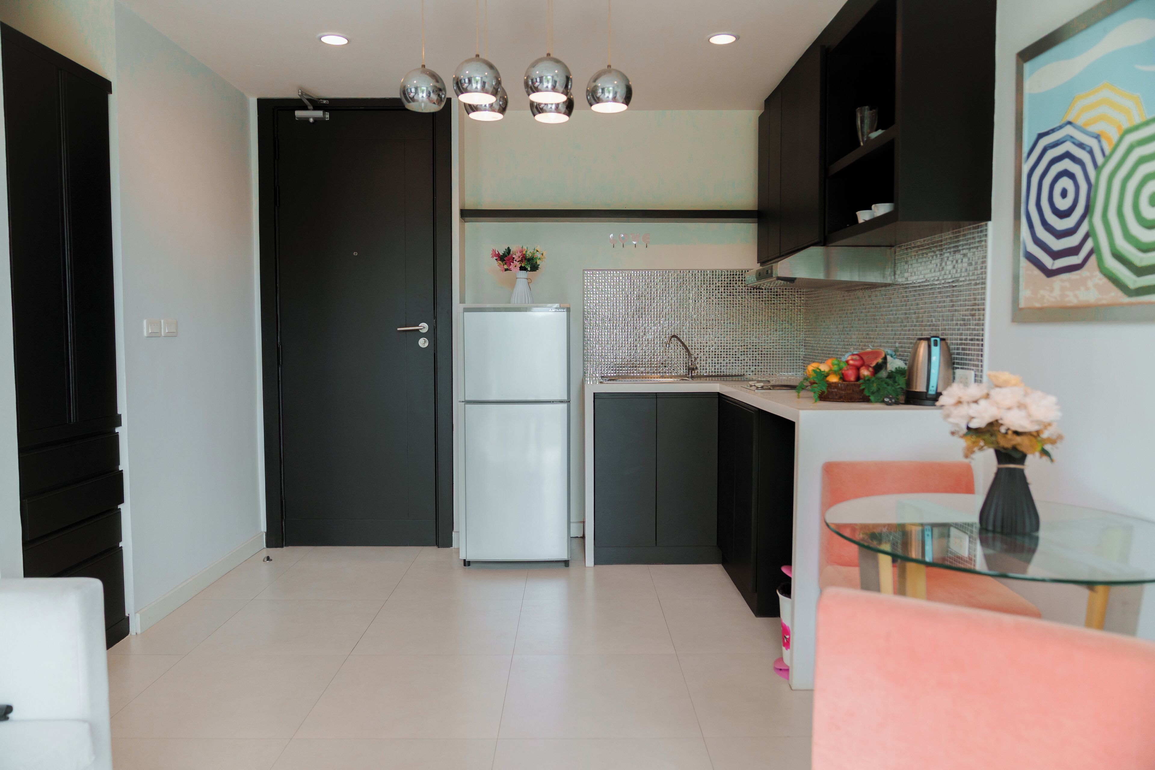 A modern kitchen with a refrigerator, sink, and dining area.