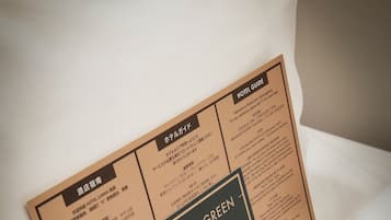 Een hotelgids brochure gedeeltelijk in een wit kussen gestoken.