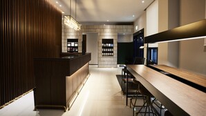 Eine moderne Hotelhalle mit einer Rezeption, einer Sitzecke und einem großen Spiegel.