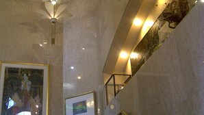 A modern interior with a ceiling fan, a staircase, and wall-mounted lighting. - Hotel Platon (Chikuma)