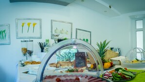 A buffet with various food items, framed artwork on the walls, and a ceiling with recessed lighting. - Hotel West (Bratislava)