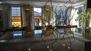 A spacious room with large windows, a wooden interior, and a modern chandelier. - Hotel West (Bratislava)