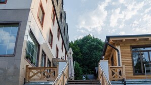 A staircase leading to a building with multiple windows and a wooden railing. - Hotel West (Bratislava)