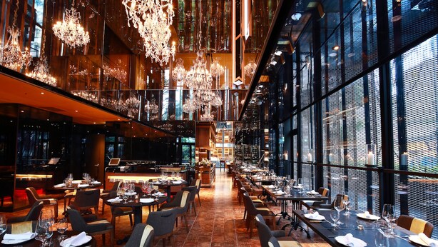 A spacious restaurant with high ceilings, modern chandeliers, and large windows offering views of the city. - Hotel Proverbs Taipei (Taipei)