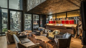 A modern interior with leather sofas, wooden tables, and a bar area with red accents. - Hotel Proverbs Taipei (Taipei)