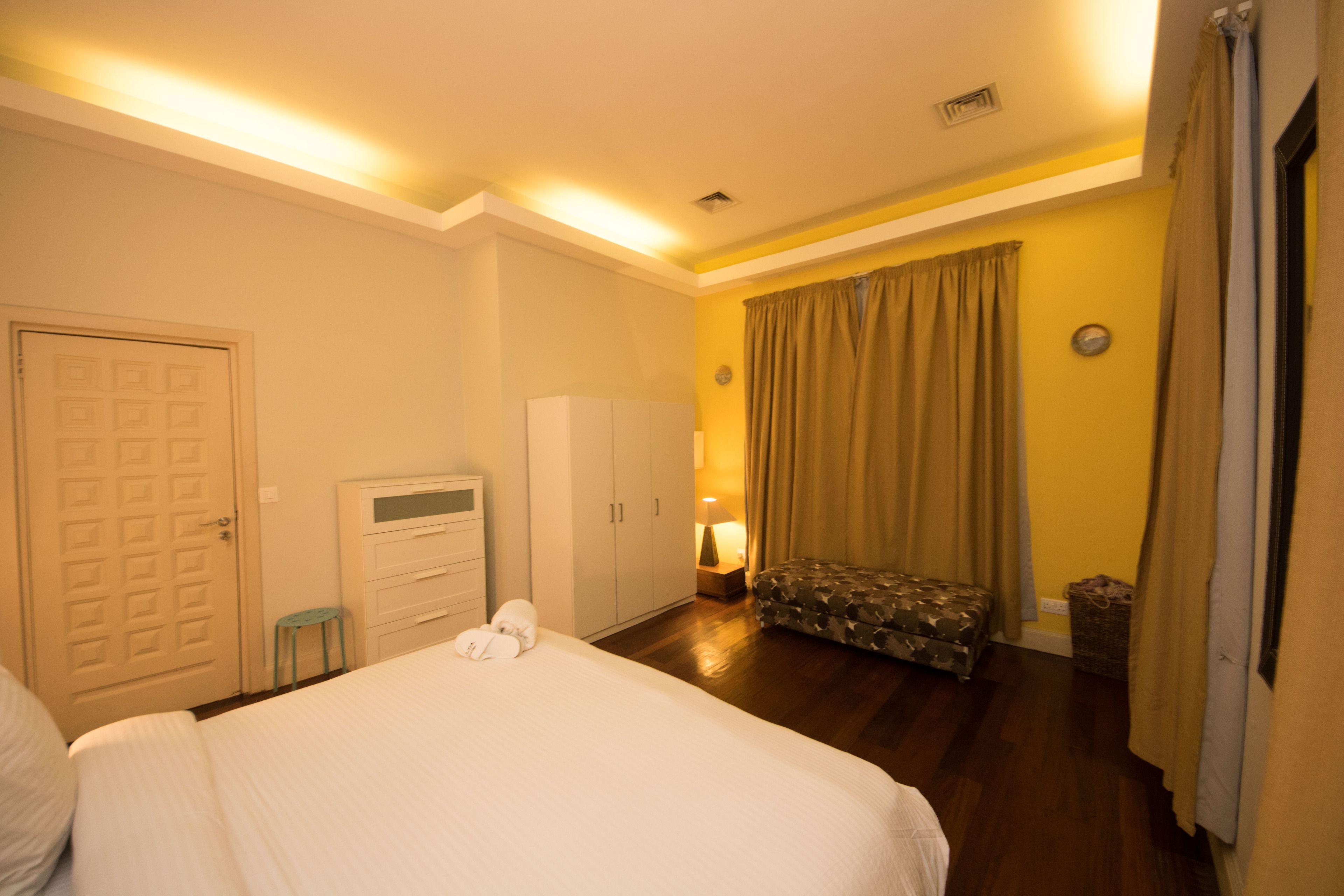 Habitación de hotel con cama, armario y una pequeña zona de estar.