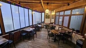 A restaurant with wooden interior, large windows, and tables and chairs arranged for dining. - Ottoman Elegance Hotel (Istanbul)