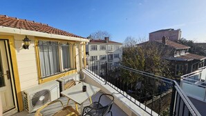 A balcony with a table, chairs, and an air conditioning unit. - Ottoman Elegance Hotel (Istanbul)
