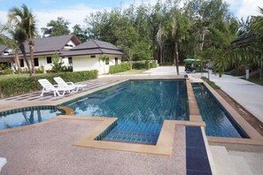 Alberca al aire libre y camastros