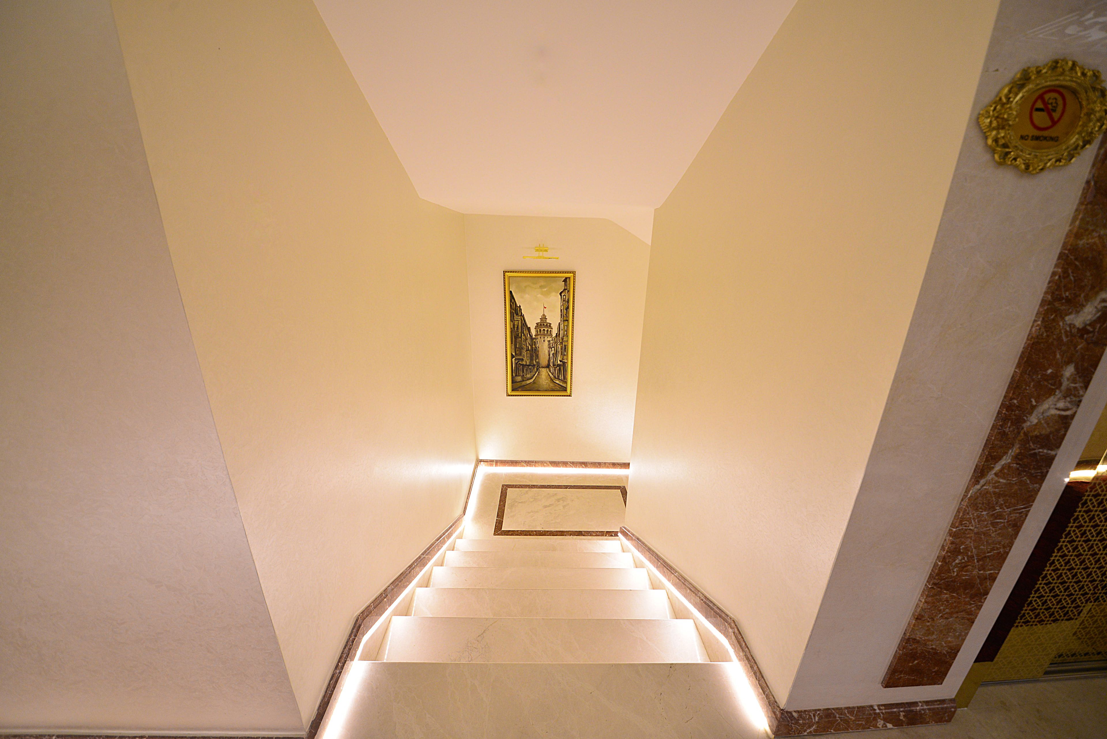 A staircase with a marble finish, a framed picture on the wall, and a 'No Smoking' sign.