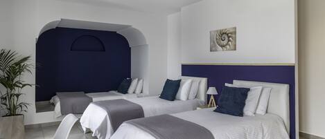 Une chambre d’hôtel moderne avec deux lits, un bureau et une plante en pot.
