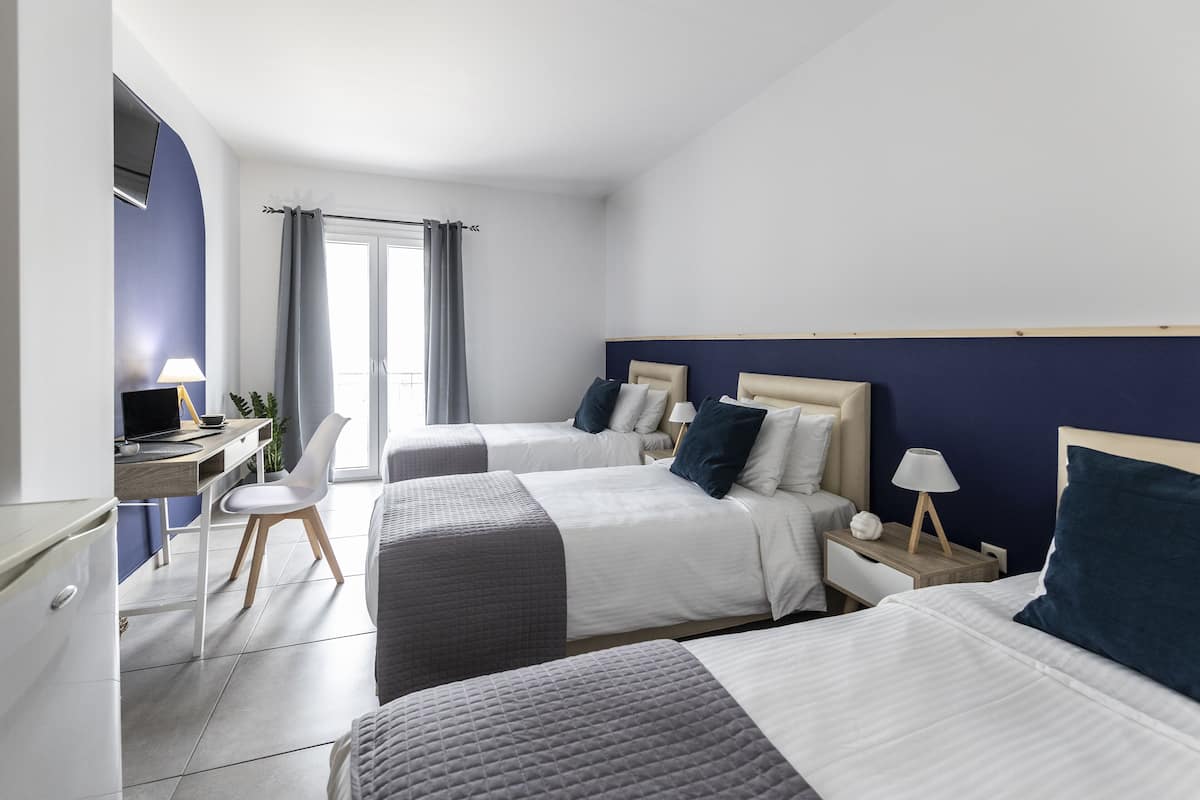 Habitación de hotel con dos camas, un escritorio y una silla.