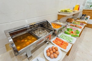 A buffet with various food items including eggs, vegetables, and meat.